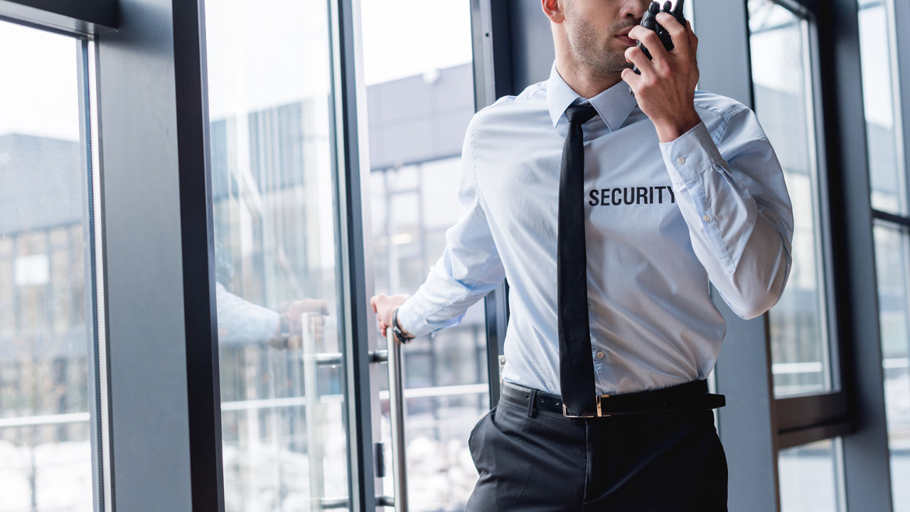 Ένας φύλακας Security στην πόρτα μιας εταιρείας εν ώρα υπηρεσίας μιλάει στον ασύρματο για τις υπηρεσίες φύλαξης εταιρειών της Kolossos Security